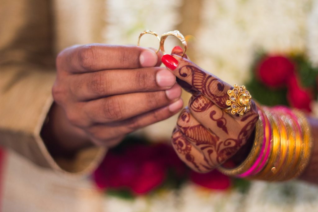 Groom and Bride holding their wedding rings